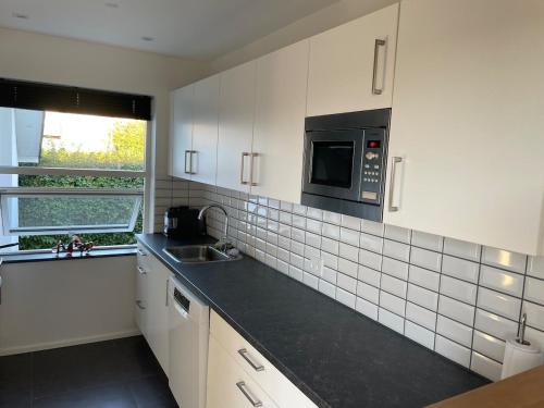 a kitchen with a sink and a microwave at Cozy house in Hjoerring close to city & nature in Hjørring