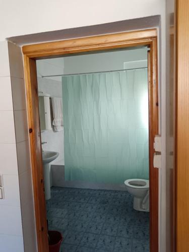 un baño con inodoro y lavabo en Super central apartment with a view, en Karpenisi