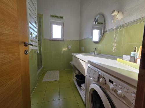 a bathroom with a sink and a washing machine at Apartments in Krk in Krk