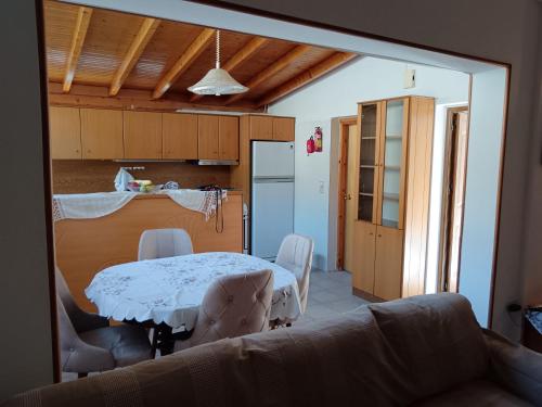 Una sala de estar con una mesa y una cocina. en Super central apartment with a view, en Karpenisi