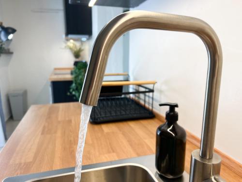 a kitchen sink with water running from a faucet at Spacious, Near Beach & Easy Parking - by Solstad in Kavala