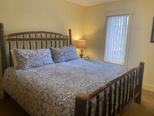 a bedroom with a bed with a wooden headboard and a window at Mountain Fun-Jack Frost Walk On Whole House in Blakeslee