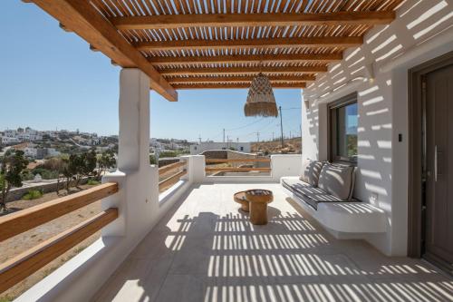 a balcony with a wooden pergola and a bench at Acres Luxe, First Floor Haven & Ground Floor Retreat in Ano Mera