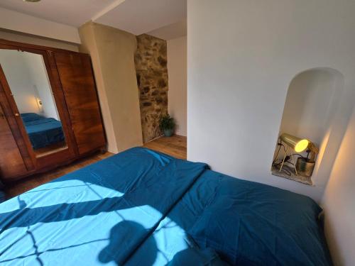 a bedroom with a blue bed in a room at Maison de pêcheur du petit port in Cagnano