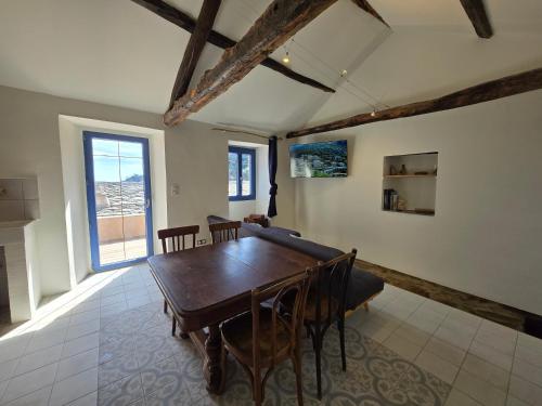 a dining room with a wooden table and chairs at Maison de pêcheur du petit port in Cagnano