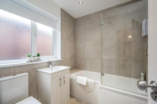 a bathroom with a tub and a toilet and a sink at StayByNumbers - City Centre Victorian Townhouse in Belfast