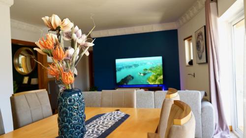 a vase with flowers on a table in a living room at Spacious Penthouse with BBQ and Views in Praia