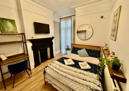 a bedroom with a bed and a fireplace at Delux Rooms Near City Centre in London