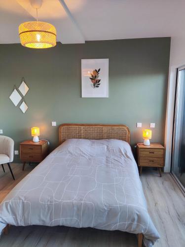 une chambre avec un grand lit avec deux tables de nuit dans l'établissement Les Lavandes, parfait pour le Thermalisme, à Balaruc-les-Bains