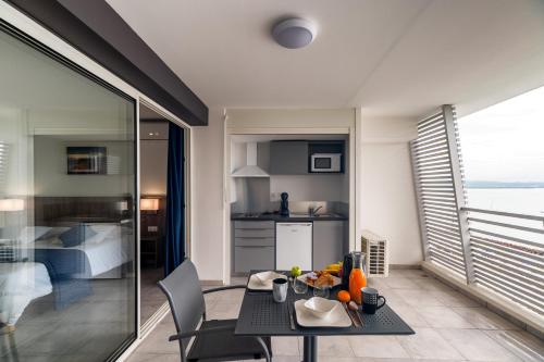 a living room with a table and a kitchen at B&B HOME Fort-de-France Marina in Fort-de-France