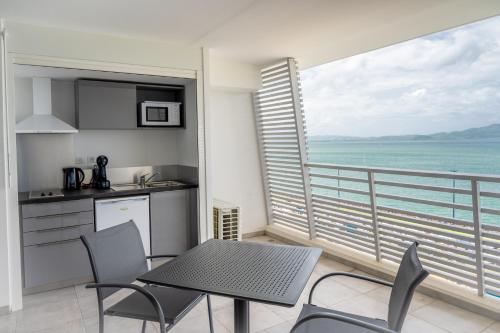a kitchen and dining room with a view of the ocean at B&B HOME Fort-de-France Marina in Fort-de-France
