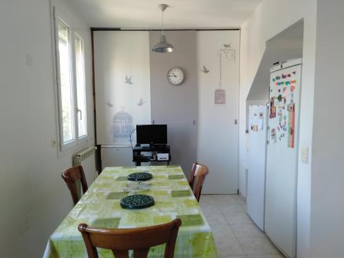 une salle à manger avec une table et un réfrigérateur dans l'établissement Chambre Proche Plage du Prophète, à Marseille