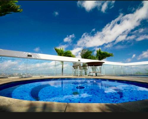 a large blue swimming pool on top of a building at Manaus Hotéis Millenium - suíte 1503 in Manaus
