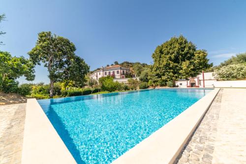 a swimming pool in a villa with blue water at Quinta da Asneira in Montemor-o-Novo