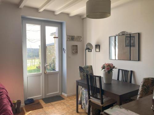 une salle à manger avec une table et une fenêtre dans l'établissement Charmant Horse and Cottage Hideaway, à Doulezon