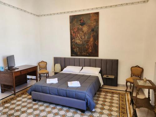 a bedroom with a bed and a painting on the wall at La Maison Royale in Toritto
