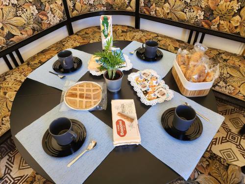 a table with utensils and food on top at La Maison Royale in Toritto