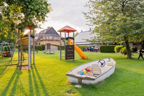 - un petit bateau sur l'herbe à côté d'une aire de jeux dans l'établissement Landhaus Ferienwohnung 1 - Bauernhof Hopp Vadersdorf, à Fehmarn