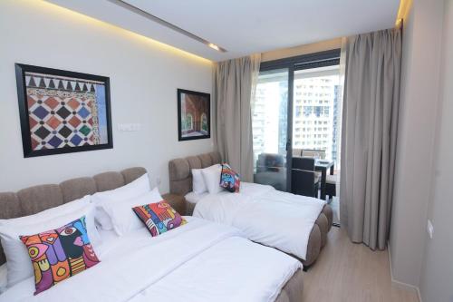 une chambre d'hôtel avec deux lits et une fenêtre dans l'établissement Andalusian Dream I 2 Bedrooms apartment near by the Beach and TGV station, à Tanger