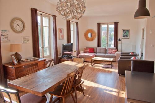 un salon avec une table et un canapé dans l'établissement Charmant T3 ,100m2, centre ville, classé 3 étoiles, à Aix-les-Bains