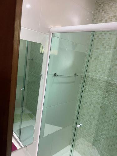 a shower with a glass door in a bathroom at Suíte 1, Caminho do Mirante in Iguaba Grande