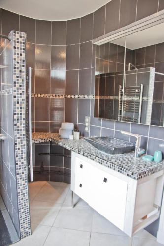 - une cuisine avec un comptoir, un évier et un miroir dans l'établissement Charmant T3 ,100m2, centre ville, classé 3 étoiles, à Aix-les-Bains