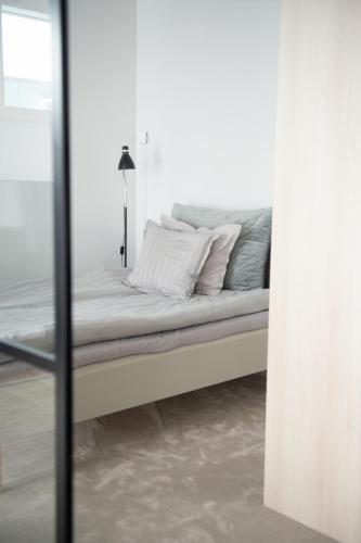 a bed with two pillows on it in a room at Neliapila Cozy Apartment in Kokkola