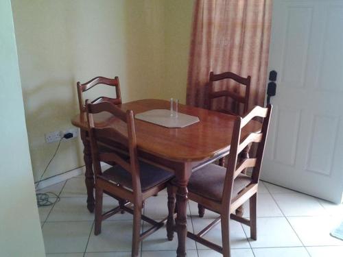 a wooden dining room table with four chairs at Aupic Paradise in Vieux Fort