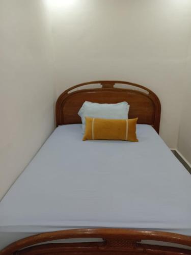 a bed with a wooden headboard and two pillows at Taghazout Flat in Taghazout