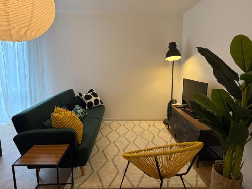 un salon avec un canapé vert et une table dans l'établissement 45m2 cosy & lumineux - Parking gratuit - Accès centre ville rapide - Check-in autonome, à Toulouse