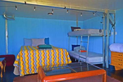 a bedroom with two bunk beds in a blue room at Mundo Abu San Juan La laguna in San Juan La Laguna