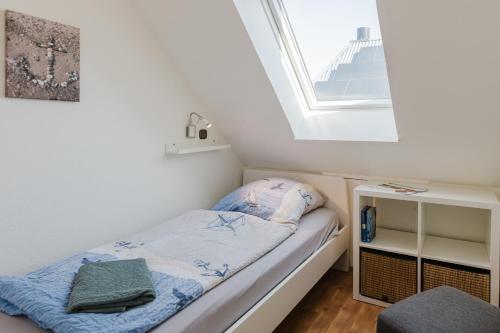 ein kleines Bett in einem Zimmer mit Fenster in der Unterkunft Landhaus Ferienwohnung 3, Bauernhof Hopp Vadersdorf in Fehmarn