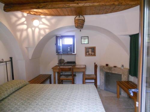 a bedroom with a bed and a table and a fireplace at Pets under the Sun in Alberobello