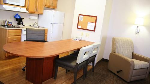 a kitchen with a table and chairs in a room at Candlewood Suites Harrisonburg by IHG in Harrisonburg