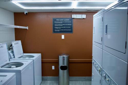 a laundry room with washing machines and a sign at Candlewood Suites Harrisonburg by IHG in Harrisonburg