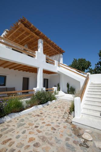 a white church with a cross and stairs at Acres Luxe, First Floor Haven & Ground Floor Retreat in Ano Mera