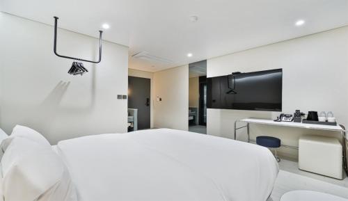 a white room with a bed and a television at 호텔그랑파리 in Gwangju