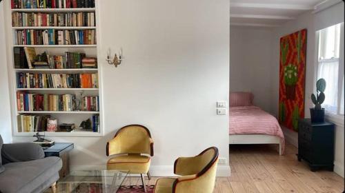 a living room with two chairs and a couch and book shelves at Captains Rest St Kilda West in Melbourne