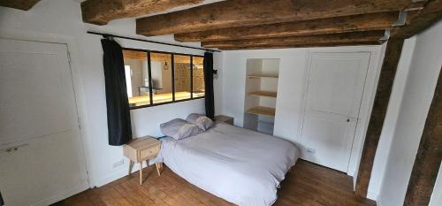 une chambre avec un lit blanc et une fenêtre dans l'établissement t2 ultra centre Poitiers 50m carrés, à Poitiers