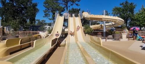 un toboggan aquatique dans un parc aquatique avec des gens dessus dans l'établissement Camping les viviers Super Mobilhome, à Claouey