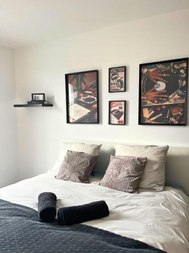 une chambre avec un lit avec quatre tableaux au mur dans l'établissement Dandy home F2 proche Paris et Aéroport Orly, à Thiais