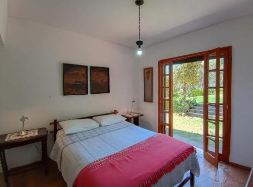 a bedroom with a bed with a red blanket at Aurora Homestead in Araras Petropolis