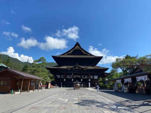 a large pagoda building with a person standing in front of it at 1166 Backpackers in Nagano