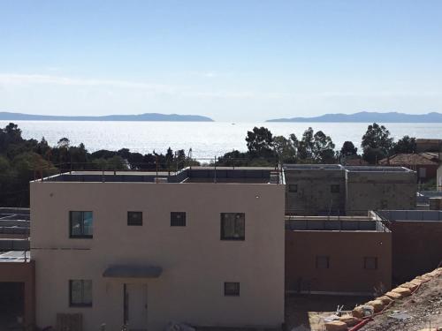 une vue sur l'océan depuis un immeuble dans l'établissement Haut de villa Vue mer, au Lavandou