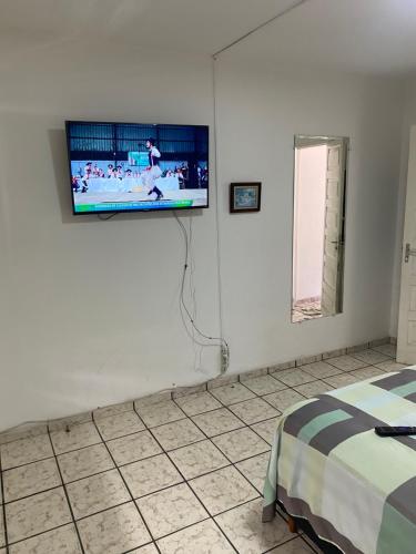 a bedroom with a flat screen tv on the wall at Duplex encantador em Guarapari-ES in Guarapari