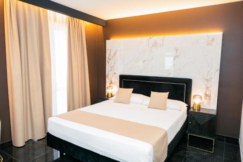a bedroom with a large bed and a large window at Hotel Brienz in Bellaria-Igea Marina