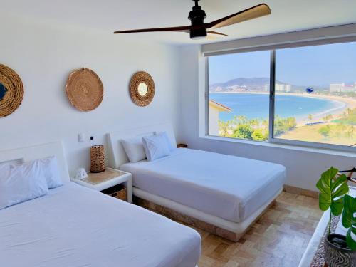 twee bedden in een kamer met uitzicht op de oceaan bij Departamentos Frente al Mar en Ixtapa in Ixtapa