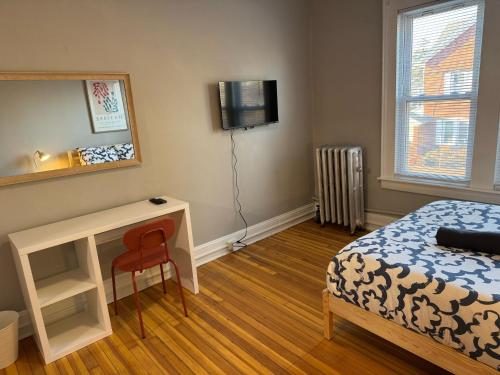 米德尔敦Private room in a shared apt Middletown near Wesley uni的一间卧室，配有一张床、一张书桌和一台电视