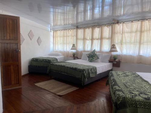 a bedroom with two beds and a window at Casa Arrecife San Bernardo del Viento in San Bernardo del Viento