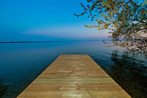 a wooden dock in the middle of a lake at PRIVATE COTTAGE GETAWAY On LAKE SIMCOE in Brechin